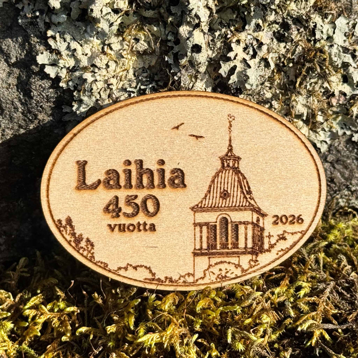 Maalaamaton soikea puumagneetti, jossa on Laihian kirkon kuva ja teksti Laihia 450 vuotta 2026.