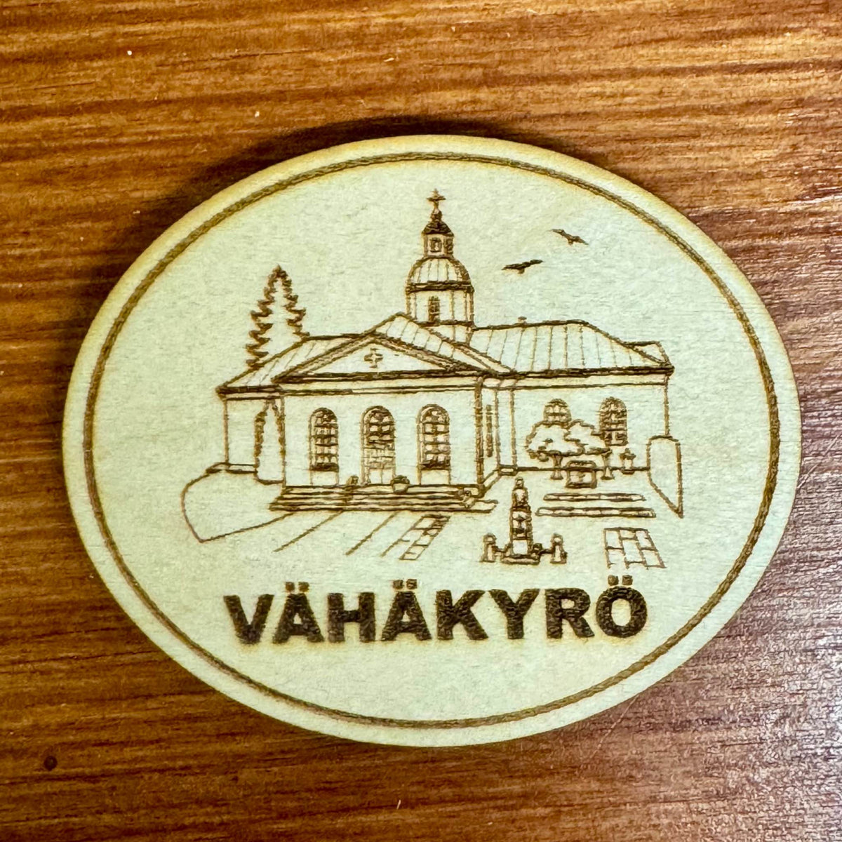 Puinen Vähäkyrö-jääkaappimagneetti, jossa on kaiverrettu kirkko ympäristöineen ja Vähäkyrö-teksti.